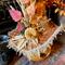 This is a close-up picture of the Halloween witch hat. It shows the hat with fall leaves, an orange pumpkin, and dried botanicals.